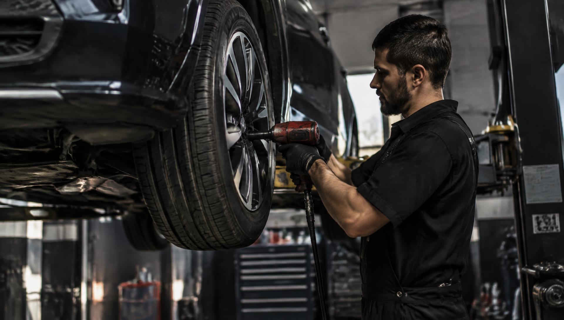 Technician servicing a wheel on a lifted vehicle